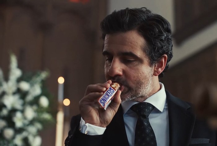 Изображение к Snickers превратил рекламу в сатиру про ИИ на похоронах